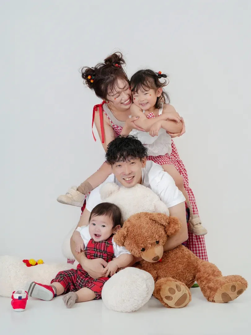 ぬいぐるみと笑顔で寄り添う家族のスタジオフォト。仙台フォトスタジオQnNe(キュンネ)