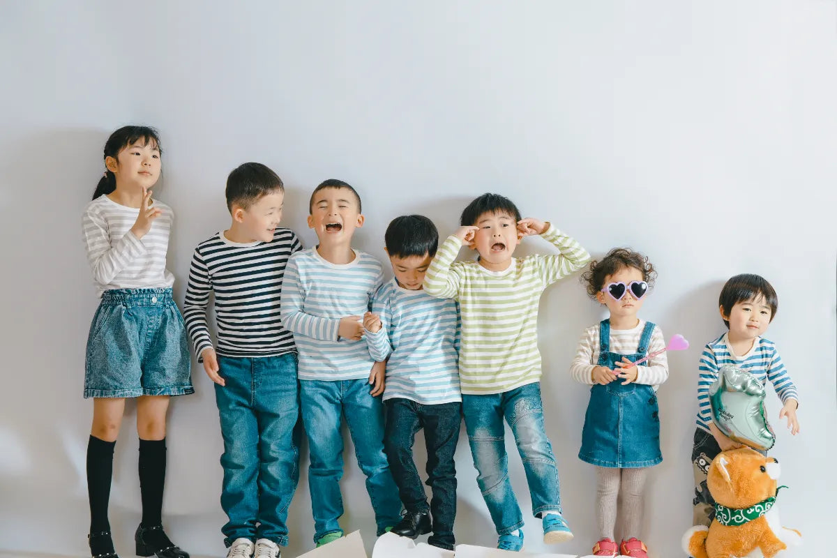 白背景のスタジオで子どもたちが笑顔で並ぶキッズフォト 仙台フォトスタジオQnNe(キュンネ)