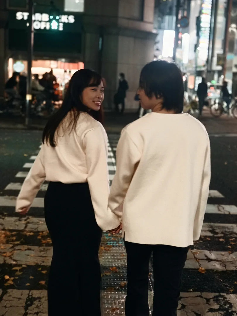 夜の街を手をつないで歩くカップルが振り向いて微笑むロケーションフォト。仙台フォトスタジオQnNe(キュンネ)