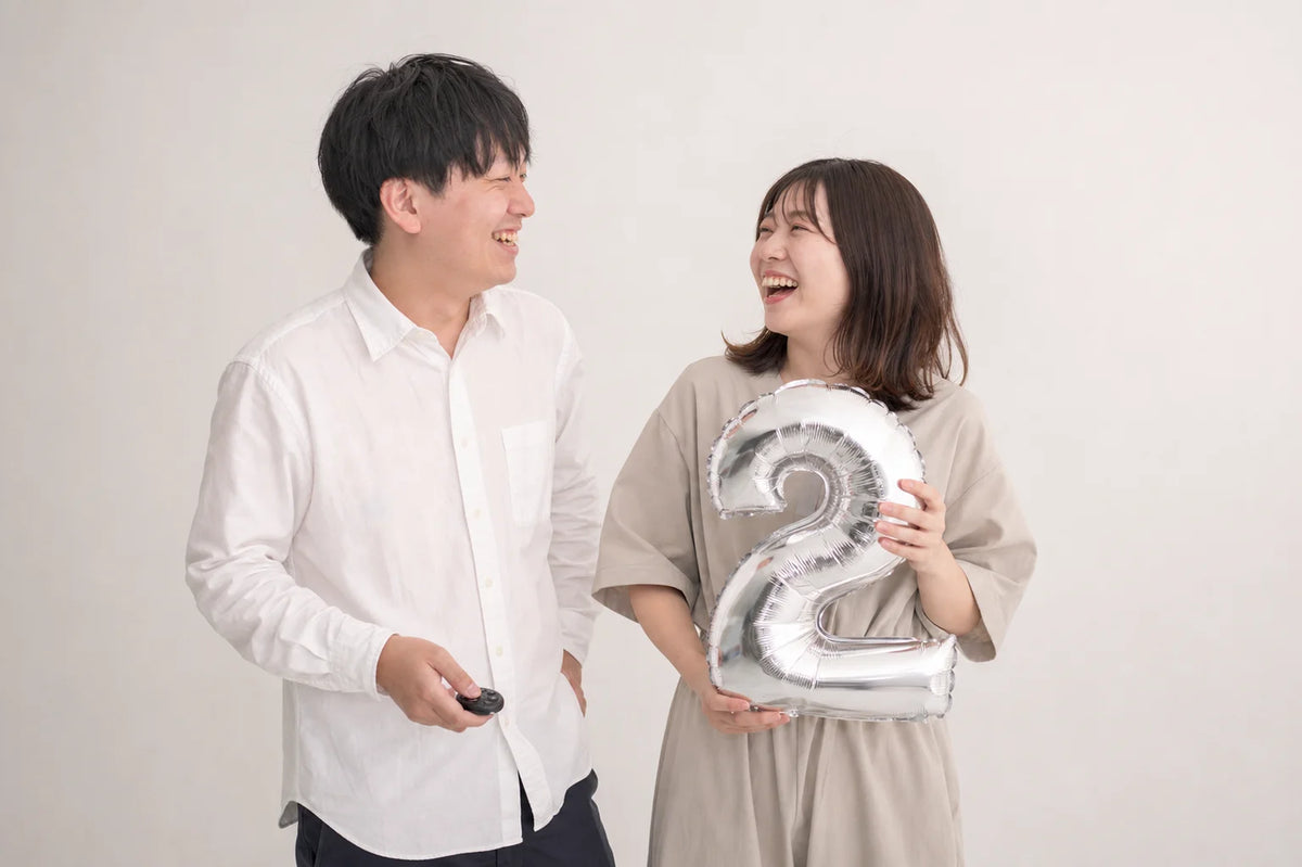 数字バルーンを持って笑い合うカップルのセルフフォト（イメージ）｜仙台フォトスタジオQnNe（キュンネ）