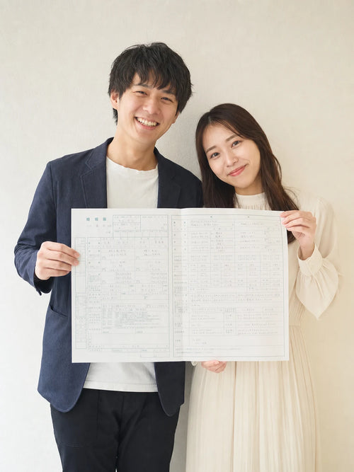 婚姻届を掲げて微笑む私服のふたりの入籍フォト｜仙台フォトスタジオQnNe（キュンネ）