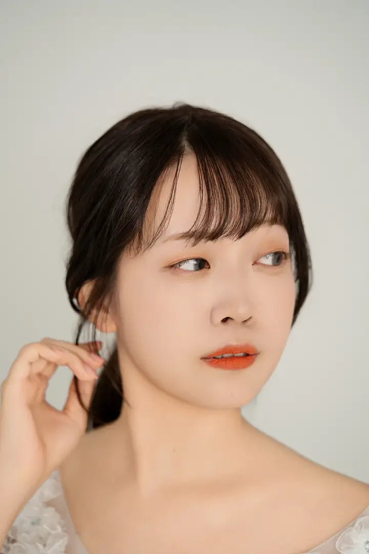 白いドレスの女性が屋上で柔らかく振り向くポートレート。自然光が美しいシンプルな写真。仙台フォトスタジオQnNe(キュンネ)