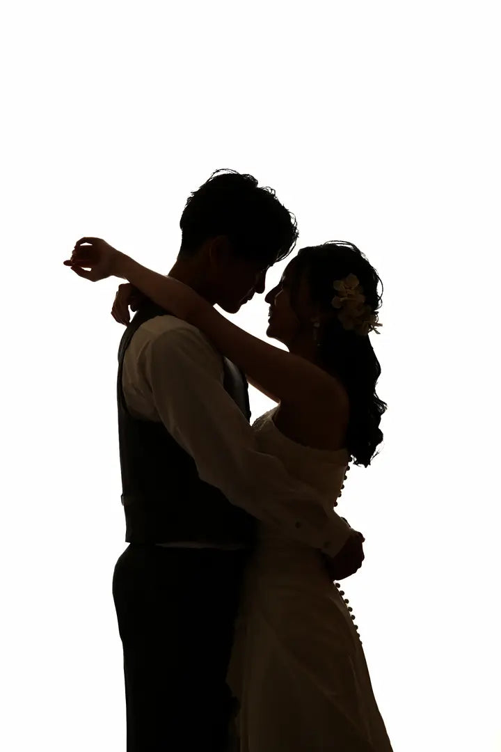 白背景で抱き合う新郎新婦の美しいシルエット写真。仙台フォトスタジオQnNe(キュンネ)
