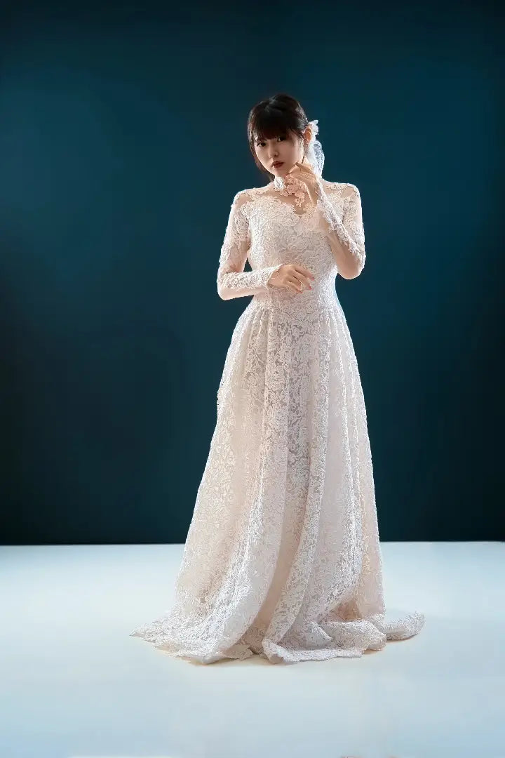 白いレースドレスを着た女性が青い背景の中で優しく微笑むポートレート。仙台フォトスタジオQnNe(キュンネ)